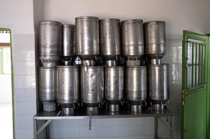 Milk churns stacked against a wall