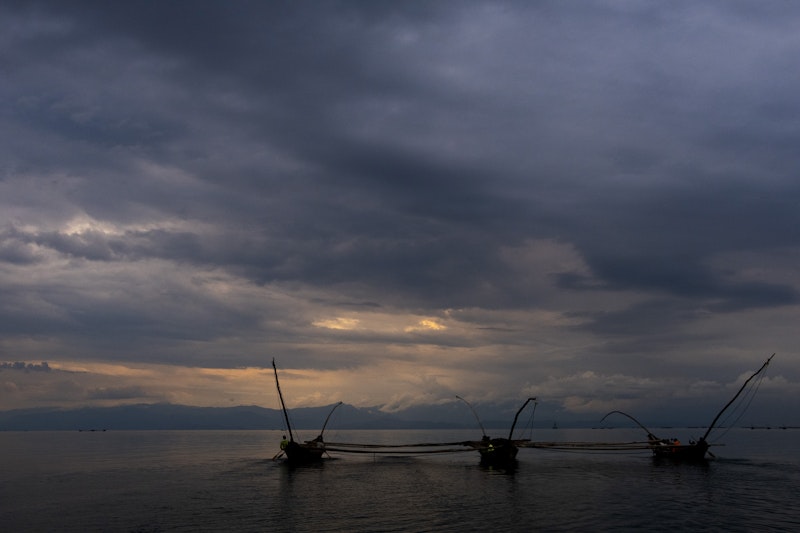 Fishing boats on a lake under a stormy sky