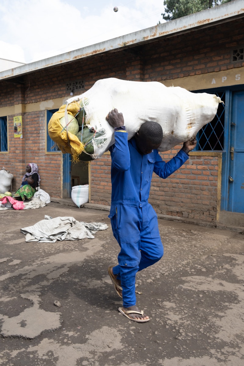 A man carrying a large sack of squash