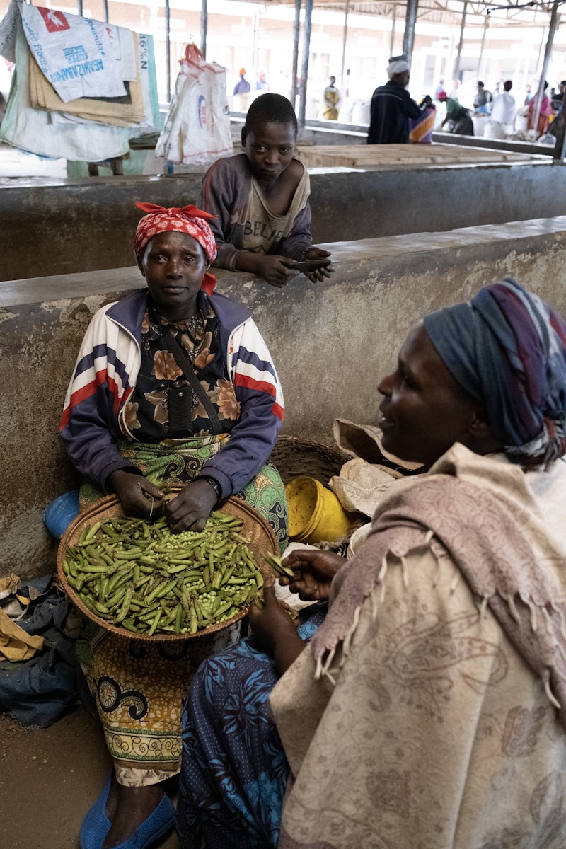 Women podding peas in a market